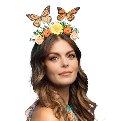 Woman wearing on her head a green, fairy diadem with 2 orange/black butterflies, 5 roses and some blades of grass.
