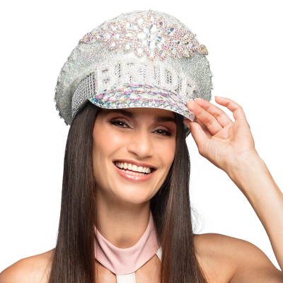 Une femme souriante aux longs cheveux noirs et raides porte une remarquable casquette blanc argent� pleine de paillettes, de pierres brillantes et de perles sur le devant, avec le texte "Bride".