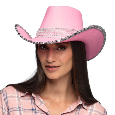 A smiling woman with long black straight hair wears a pink cowboy hat with silver pailette brim and a band of shiny stones.