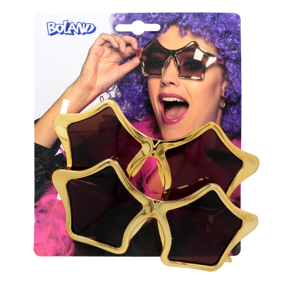 2 Gold-coloured glasses with star-shaped lenses on a packaging card. The card is printed with a picture of a woman with purple groove wig, pink boa and star-shaped glasses on. The card has a euro lock.