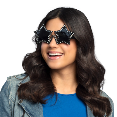Smiling woman with long wavy black hair wears black party glasses with shiny stones on the frame and dark lenses in the shape of a star.