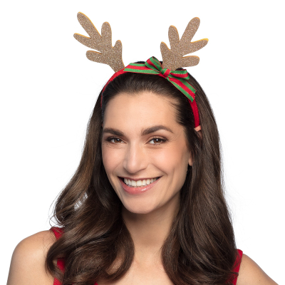 Woman wearing a Christmas diadem with gold glitter antlers on her head. The diadem has a red band and features a green/red bow.