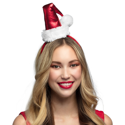 Vrouw met een rode diadeem met een mini kerstmuts op haar hoofd. 
