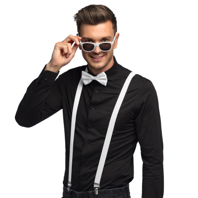 Lachende man draagt een zwarte blouse met donkere spijkerbroek in combinatie met een witte accessoireset bestaande uit een witte partybril, vlinderstrik en bretels.