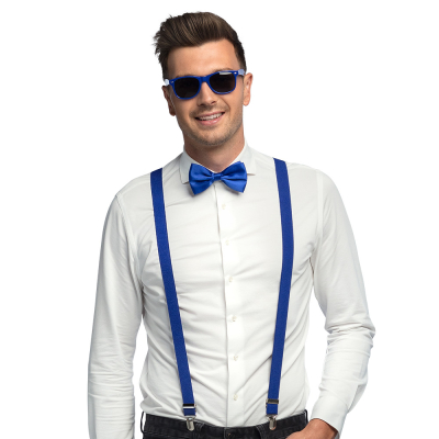 Smiling man wearing a white blouse with dark jeans combined with a dark blue accessory set consisting of dark blue party glasses, bow tie and braces.