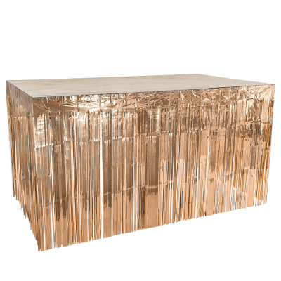 A table surrounded by a rose gold table foil curtain as decoration.