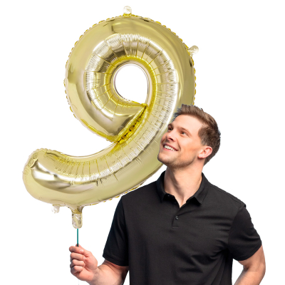 Gold foil balloon in the shape of the numeral 9.