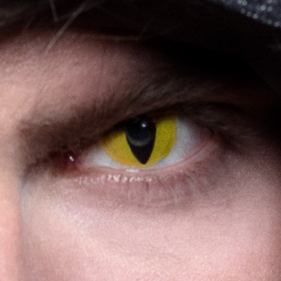 Oog met Halloween lens in geel met zwart in vorm van een kattenoog.