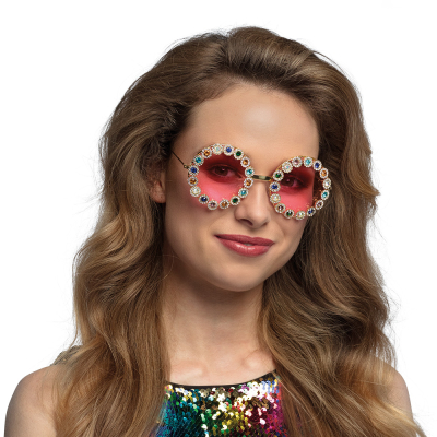 Vrouw met ronde hippie bril met roze glazen en gekleurde diamantjes rondom.