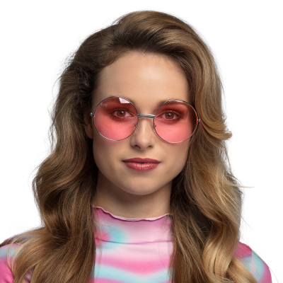 Woman wearing large round hippie glasses with pink lenses.
