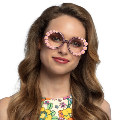 Woman wearing round hippie glasses with pink flowers and diamonds.