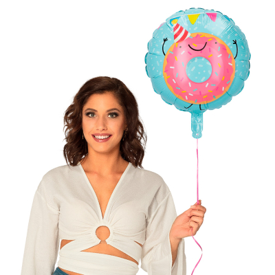 A light blue foil balloon with the design of a big pink donut with sprinkles, a smiling face and a red/white party hat on.