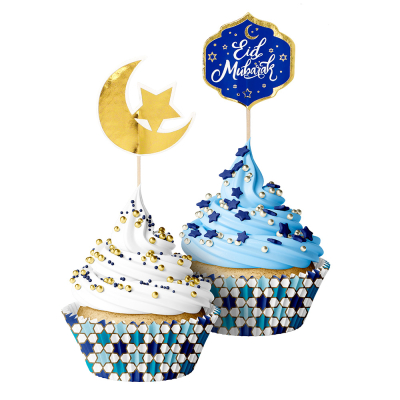2 Cupcakes in paper Eid Mubarak cupcake moulds. The cupcake has a toothpick inserted with the text Eid Mubarak and the other cupcake a toothpick with a golden moon and star.