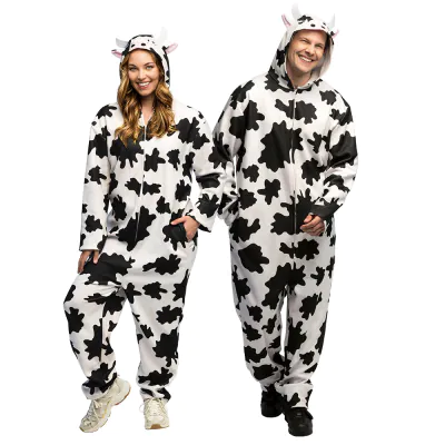 A man and woman wear the same funny cow costume that consists of a soft jumpsuit with pockets and a cute hood with ears and horns.