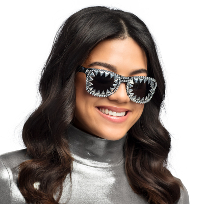 Woman wearing black party glasses with rhinestones on the frame and silver triangles on the lenses.