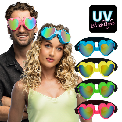Man en vrouw dragen oversized hartvormige skibrillen. De bril is verkrijgbaar in neon roze, blauw, geel en groen. UV-reactief, dus perfect voor rave of festival.