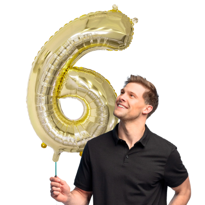 Gold foil balloon in the shape of the numeral 6.
