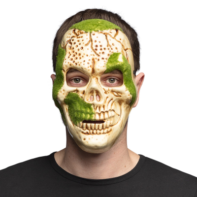 Un homme porte un masque de squelette avec un crâne détaillé décoré de mousse verte, comme accessoire pour un terrifiant costume d'Halloween.