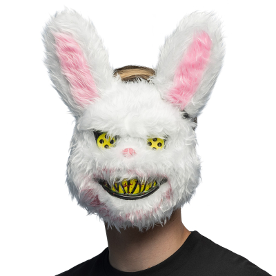 Un homme portant un masque de lapin d'horreur en peluche avec un rictus effrayant aux dents jaunes pointues, des yeux jaunes à boutons avec des éclaboussures de sang et une fourrure ensanglantée, comme accessoire pour un terrifiant costume d'Halloween ou 