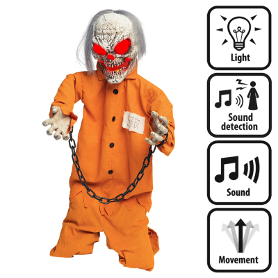 A standing halloween decoration of a skeleton in an orange prisoner costume with a chain around his hands sitting on his knees. The doll makes scary noises, movements, has glowing red eyes and is activated by sound.