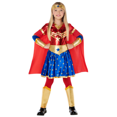 Meisje draagt een superhelden kostuum met rood shirt, blauwe rok met sterren design, rode cape en bijpassende gouden hoofdband, riem en arm- en beenbeschermers. Erg leuk voor carnaval, cosplay en kinderfeestje.