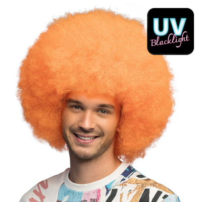 Man wears a large, full neon orange afro wig as an accessory for a neon fancy dress party, disco fancy dress party or colourful carnival costume.