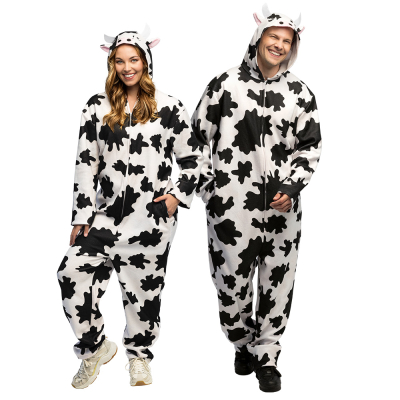 Een man en vrouw dragen hetzelfde grappige koeienkostuum dat bestaat uit een zachte jumpsuit met zakken en een leuke capuchon met oortjes en hoorntjes.