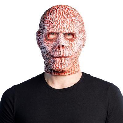 Ein Mann trägt eine Halloween-Latexmaske mit einem gefilzten Gesicht, das Fleisch mit Muskeln zeigt.